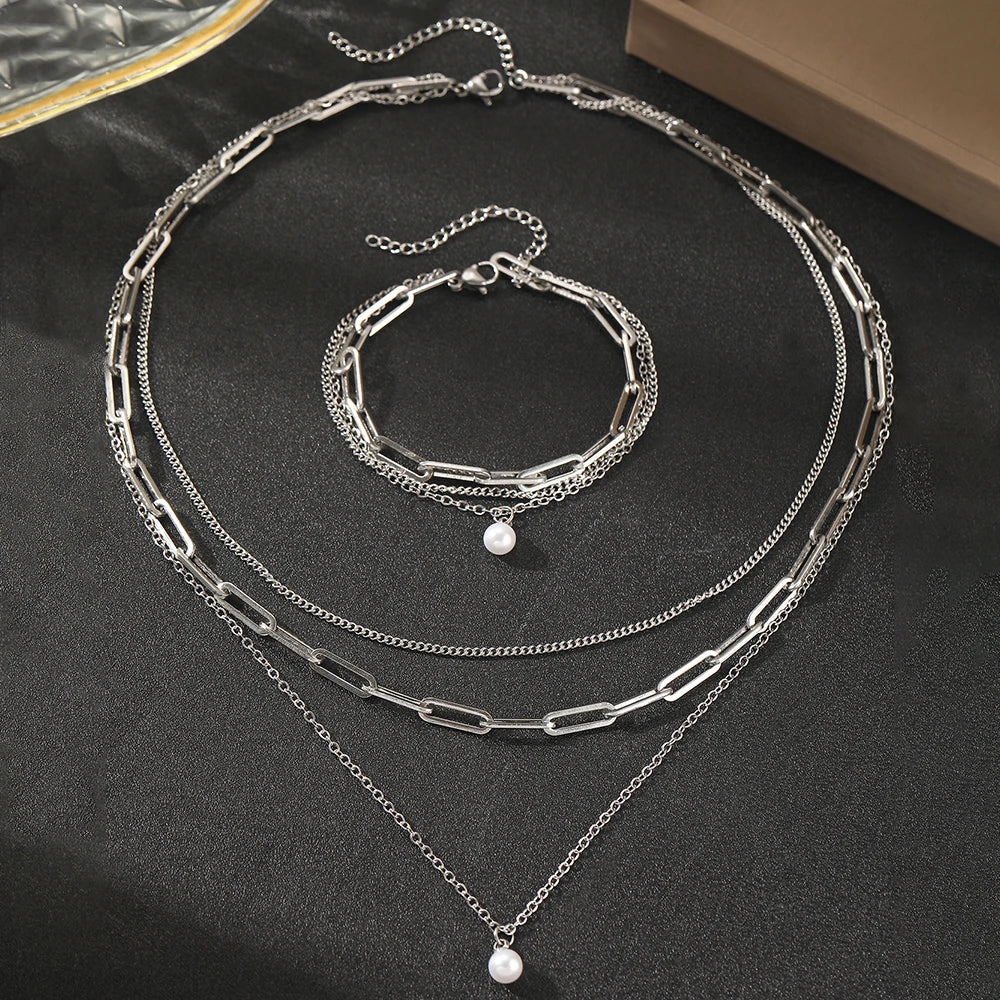 Ensemble de bijoux Aomogo en acier inoxydable, comprenant un pendentif en perle délicate et une chaîne multicouche de luxe pour femme.