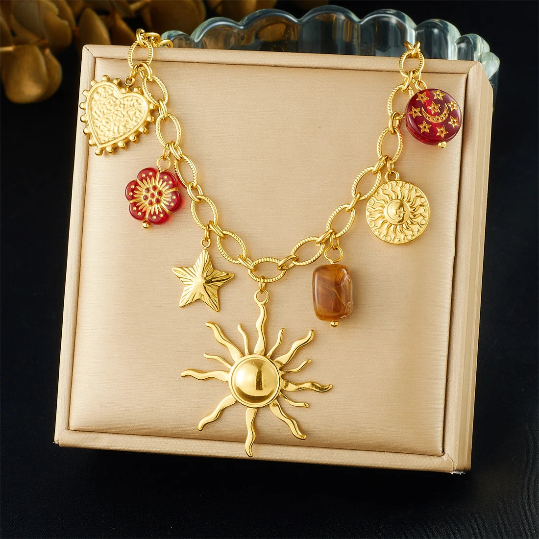 Collier pendentif DIEYURO en acier inoxydable 316L, orné d'un soleil, d'une étoile, d'un cœur et d'une fleur rouge. Étanche, il s'agit d'une chaîne à maillons pour femme, idéale pour les fêtes.