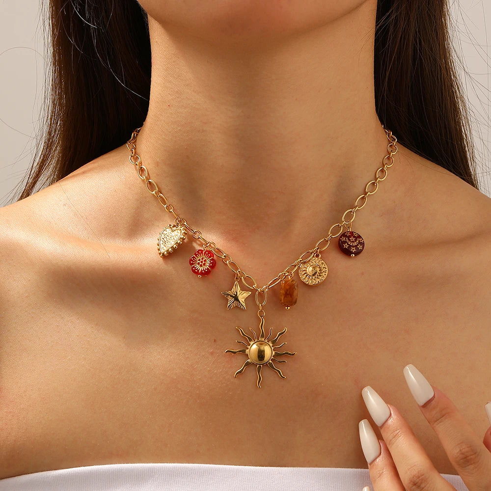 Collier pendentif DIEYURO en acier inoxydable 316L, orné d'un soleil, d'une étoile, d'un cœur et d'une fleur rouge. Étanche, il s'agit d'une chaîne à maillons pour femme, idéale pour les fêtes.