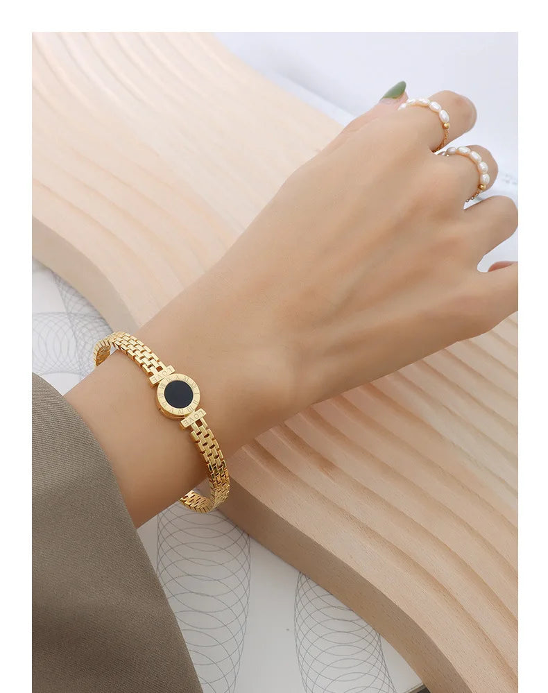 Bracelet jonc en acier chirurgical plaqué or 18 carats avec inscription « Retour à Rome » et chiffres romains.